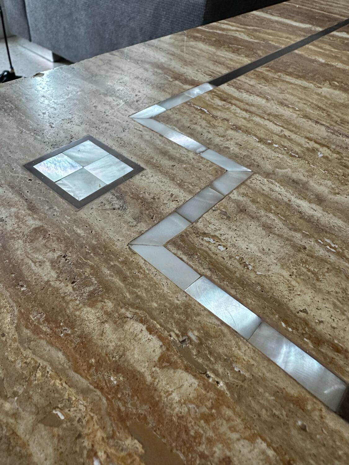 Coffee table in travertine with mother-of-pearl inlays.