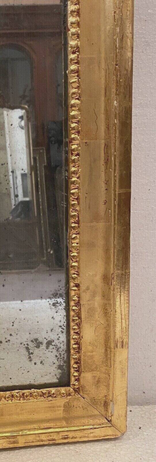 Louis XVI mirror in carved and gilded wood with leaf 18th century
