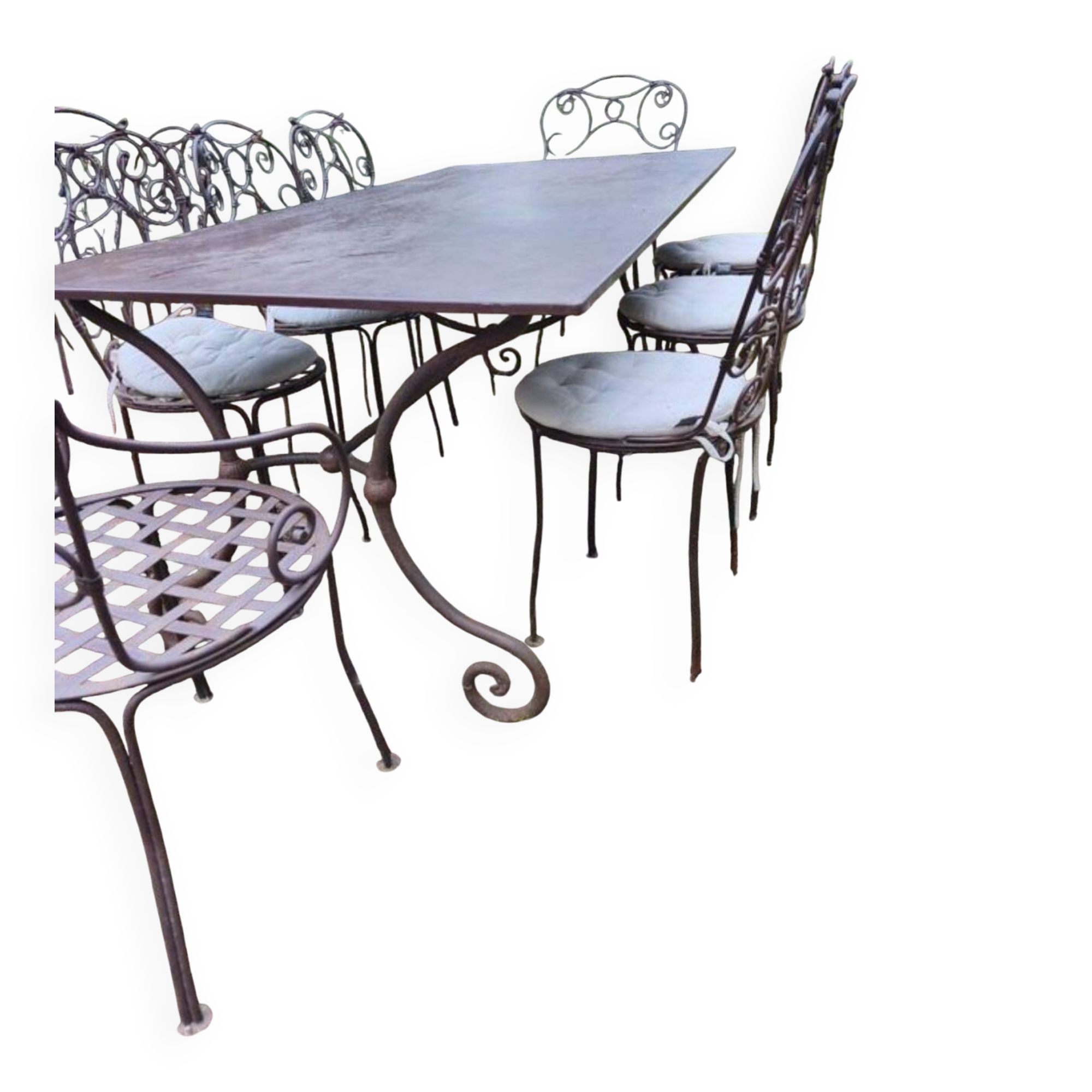 Old wrought iron table and its armchairs and chairs for outdoor use.