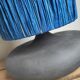 Table lamp in black stoneware and natural raffia.