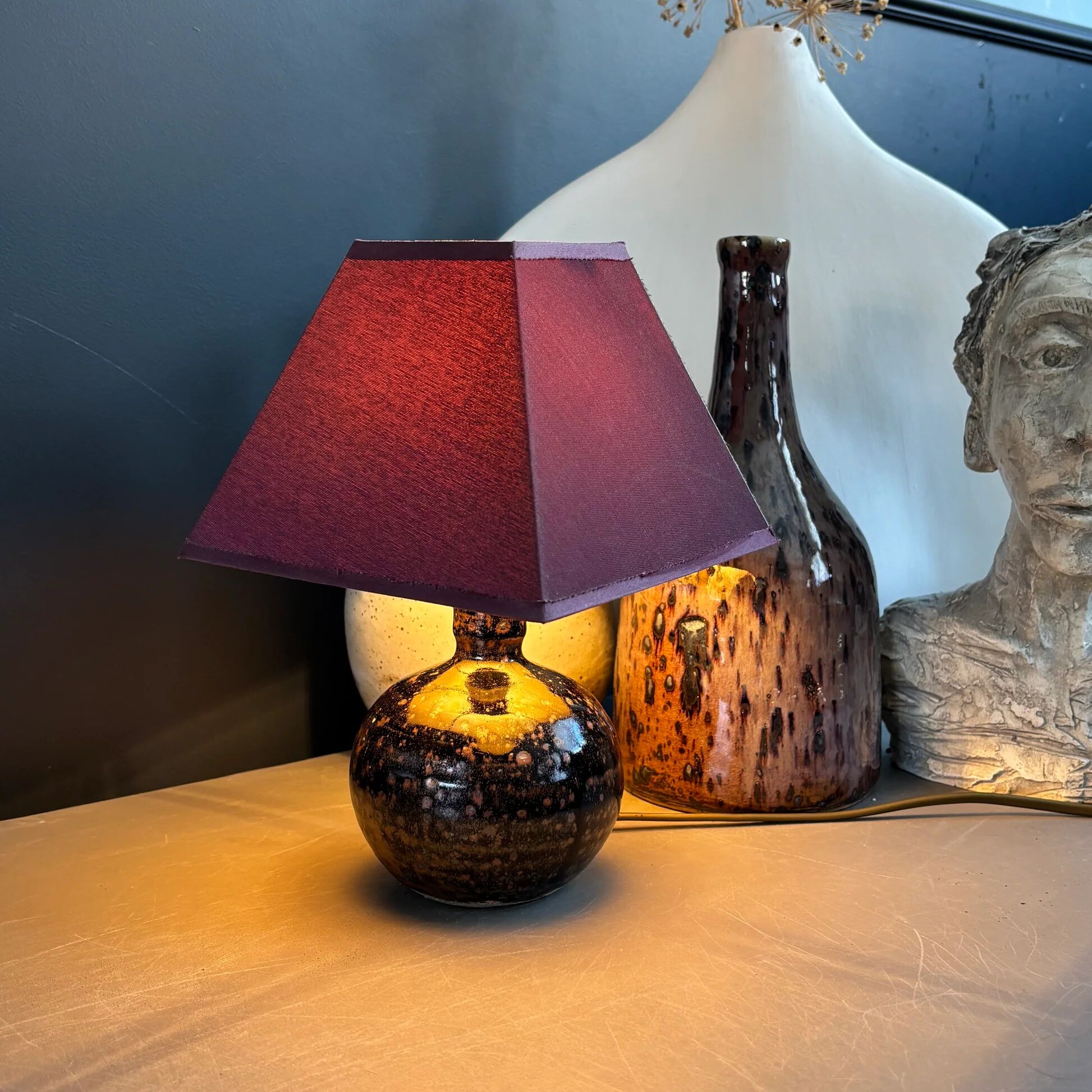Ceramic floor lamp with a pyramidal shade and square base.