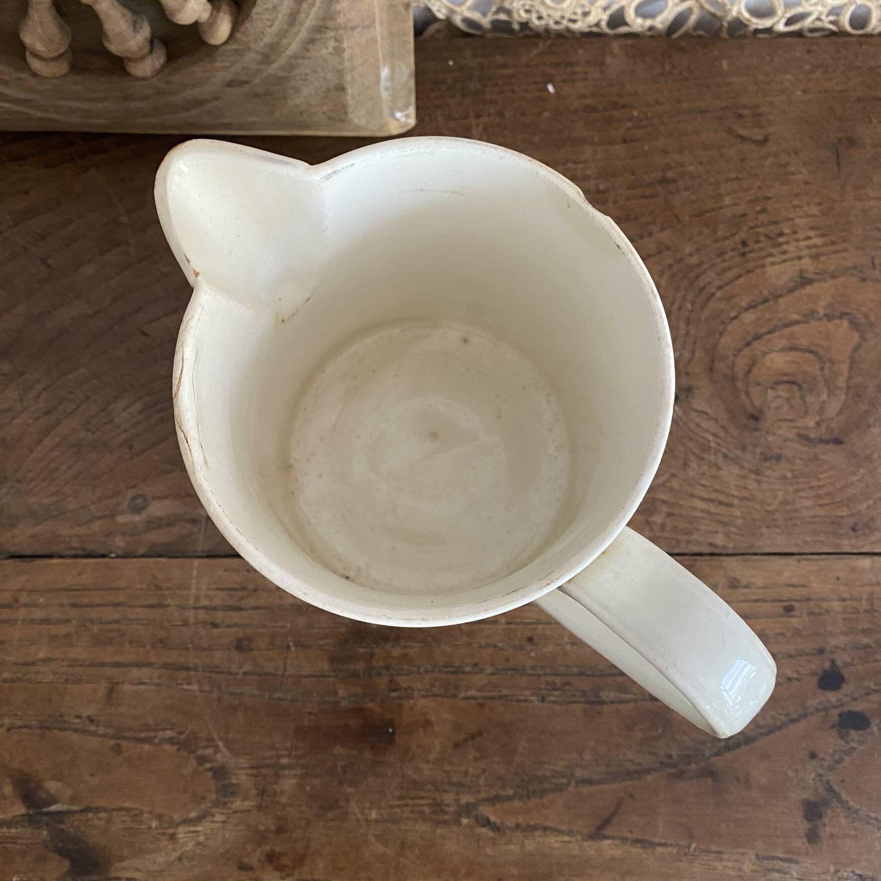 Old ceramic pitcher with orange decoration.