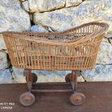 Old rattan cradle on wheels