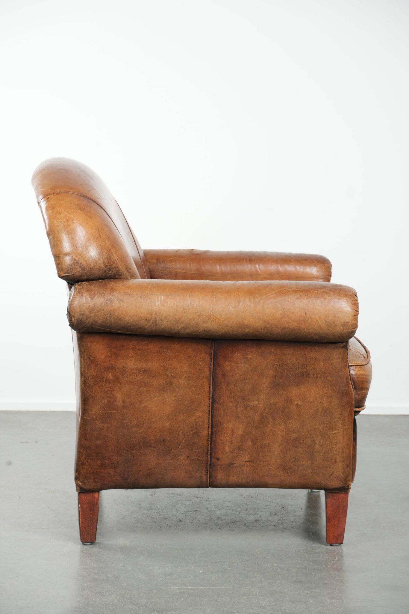 Sheepskin armchair with a beautiful vintage look and decorative nail finish