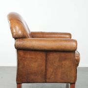 Sheepskin armchair with a beautiful vintage look and decorative nail finish