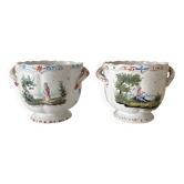 Pair of antique cache pots in French faience, decorated with pastoral scenes.