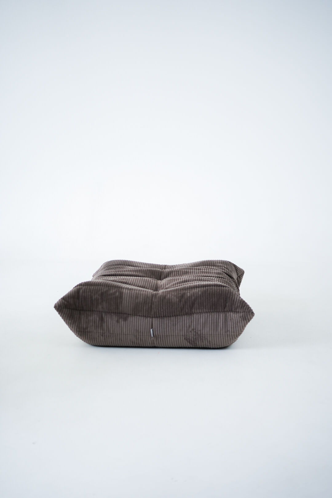 Ensemble de chaise et pouf Togo en velours côtelé marron.