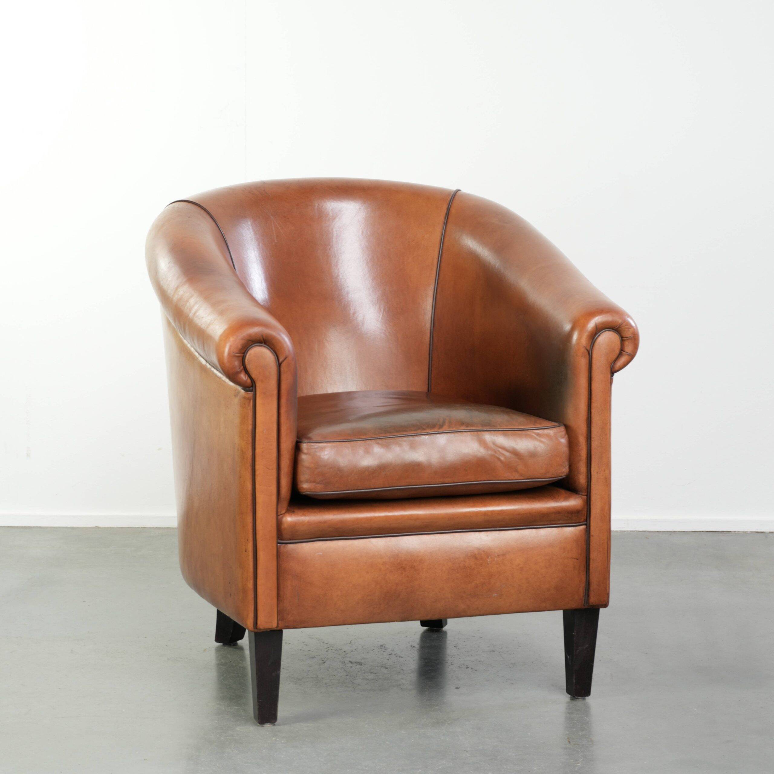 Vintage sheepskin club armchair with a warm colour scheme with black piping