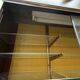 Vintage wooden and glass display cabinet, 15 shelves, gold background.