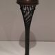 Brass ashtray on a stand made of black lacquered metal wire.