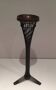 Brass ashtray on a stand made of black lacquered metal wire.