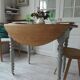 Walnut table with raised flaps, base on verdigris casters.
