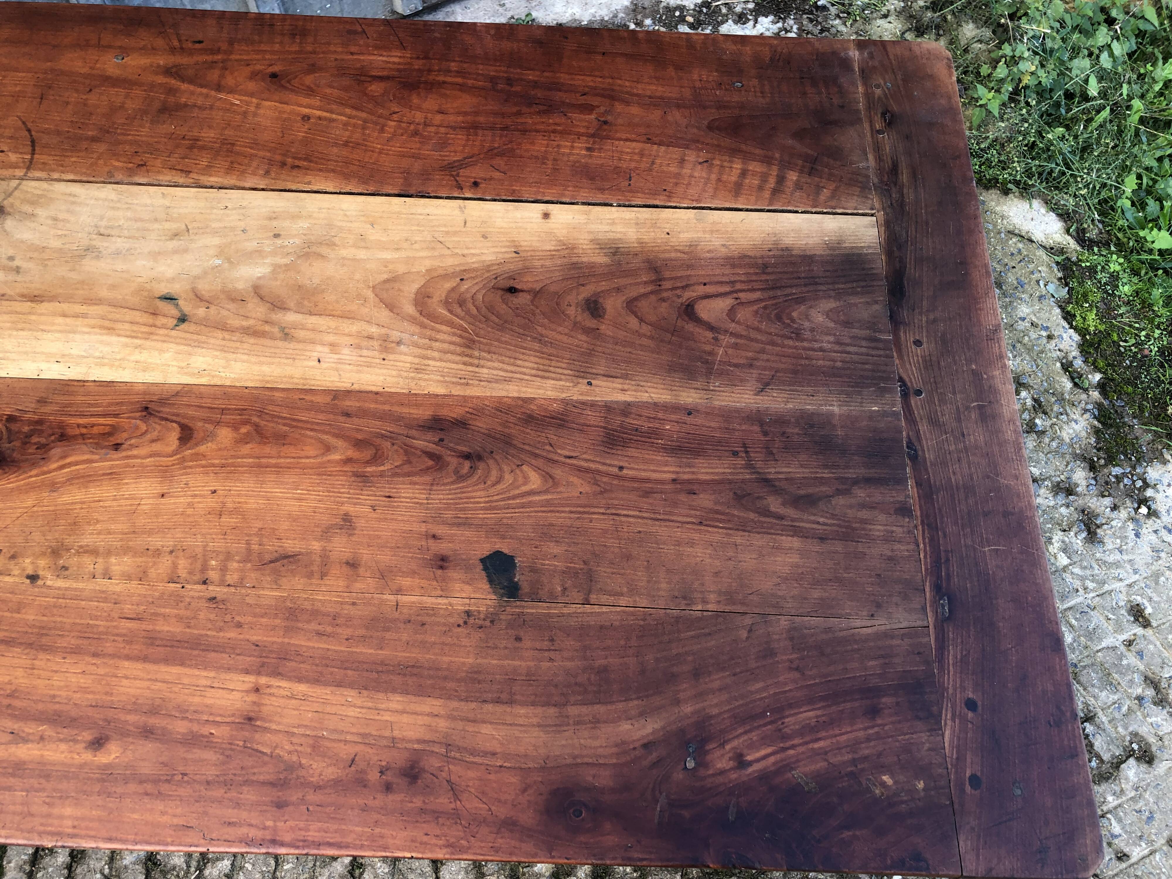 Antique farmhouse table in solid cherry wood with turned legs.