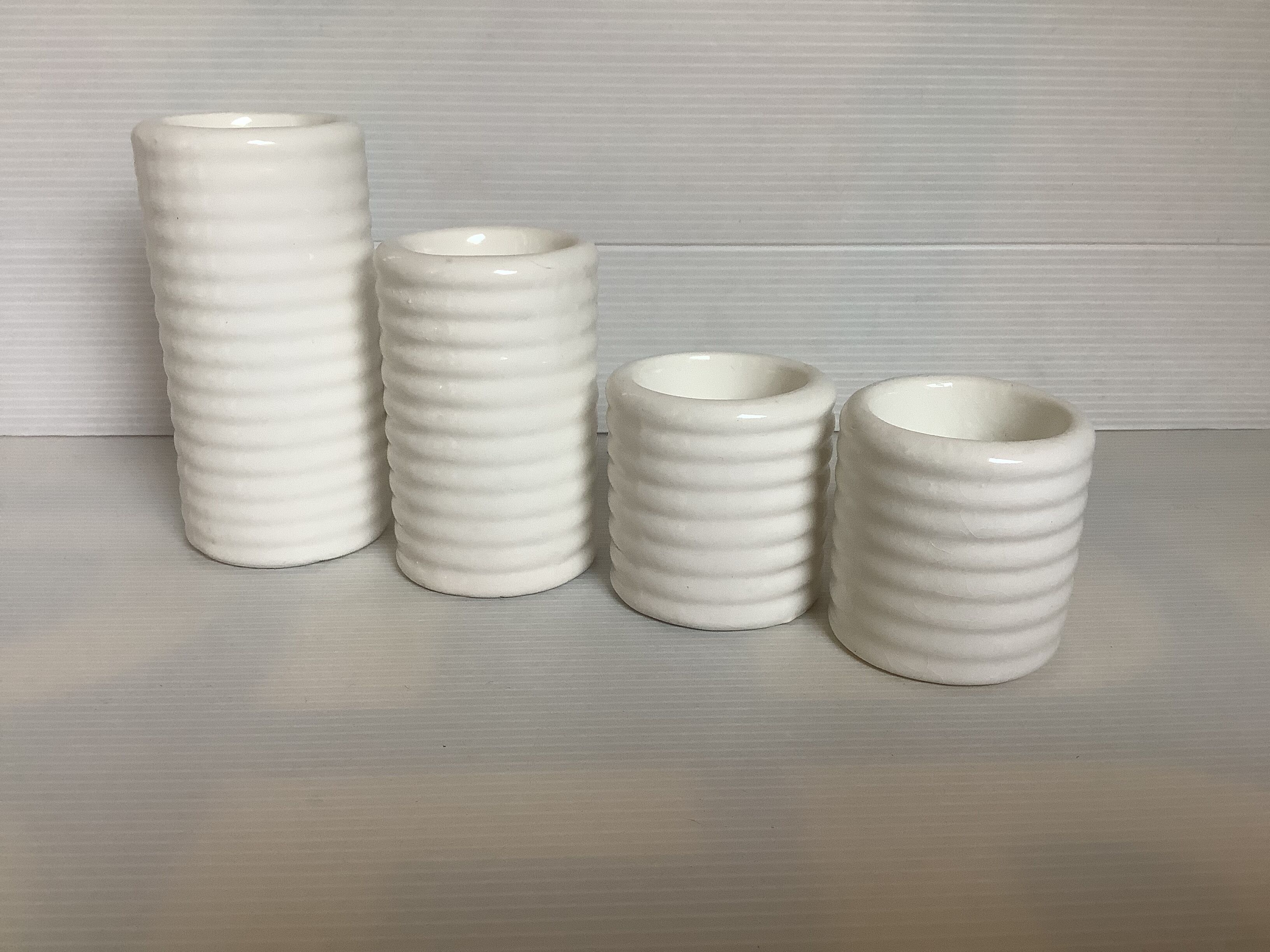Four white earthenware candle holders