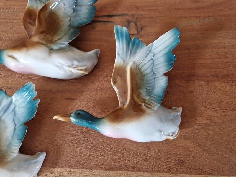 Série de 3 canards en vol en faience allemande - marque au dos
