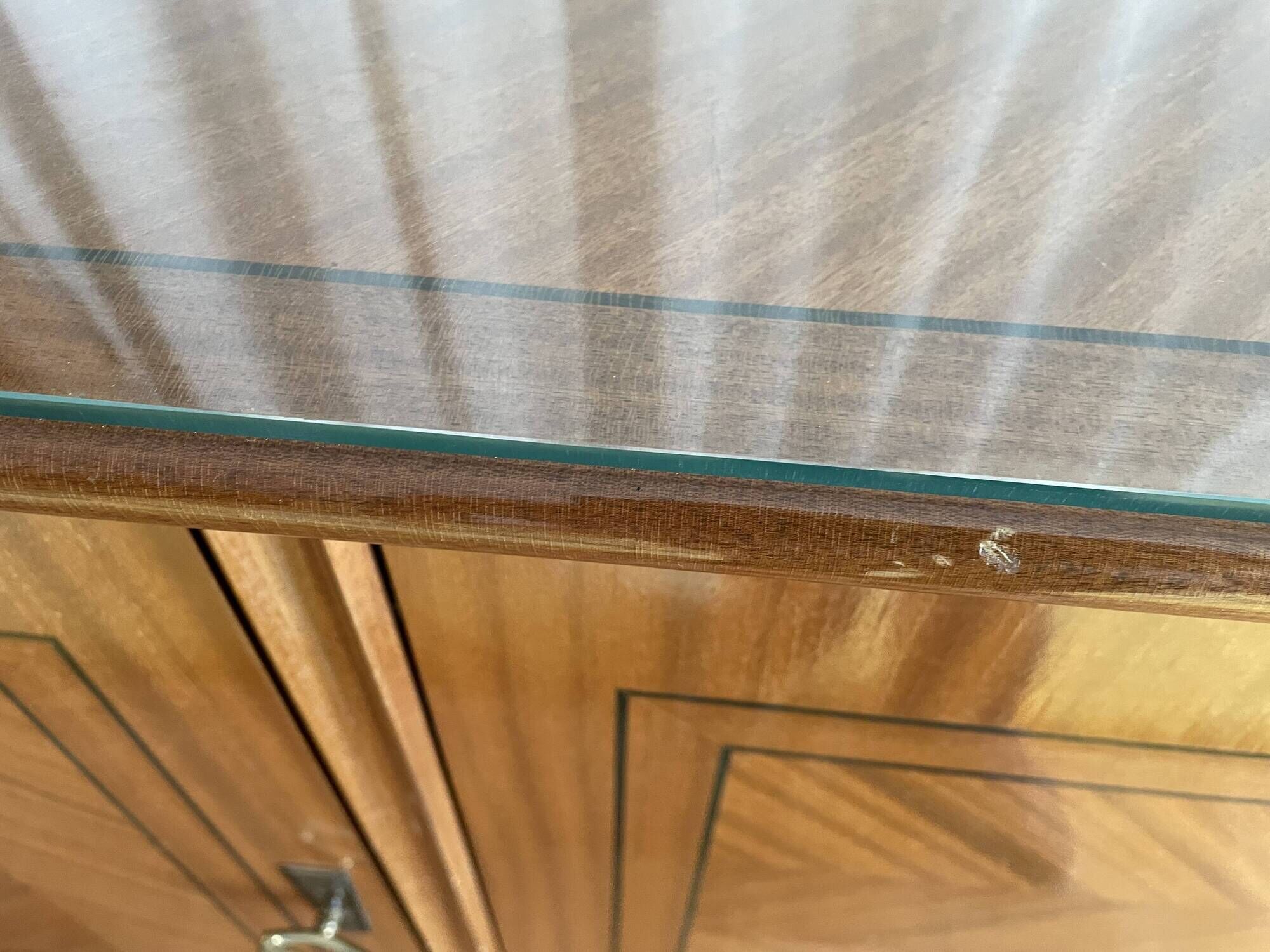 Vintage 4-door buffet with wood veneer and glass top.