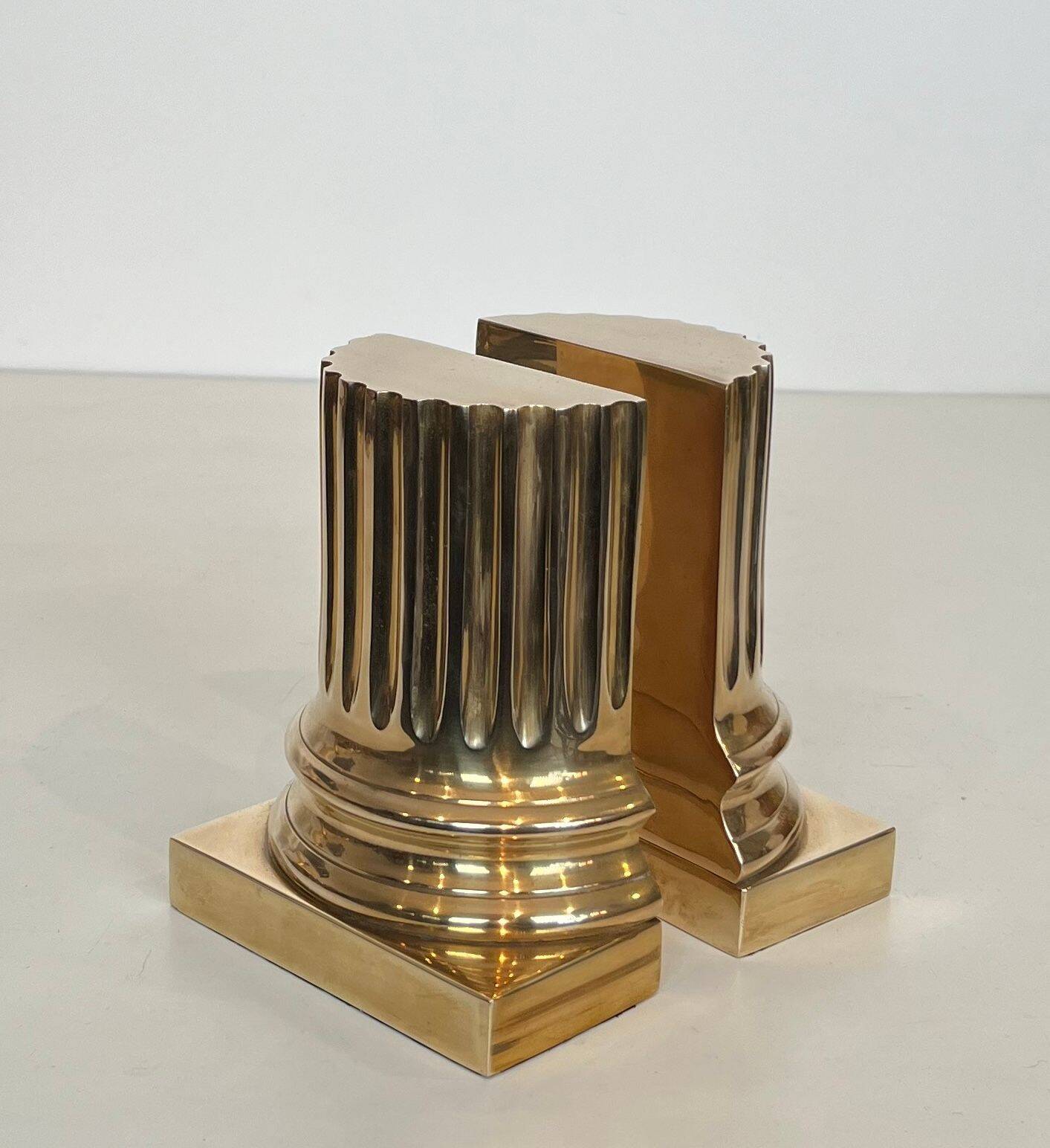 A pair of brass bookends representing columns.