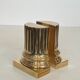 A pair of brass bookends representing columns.