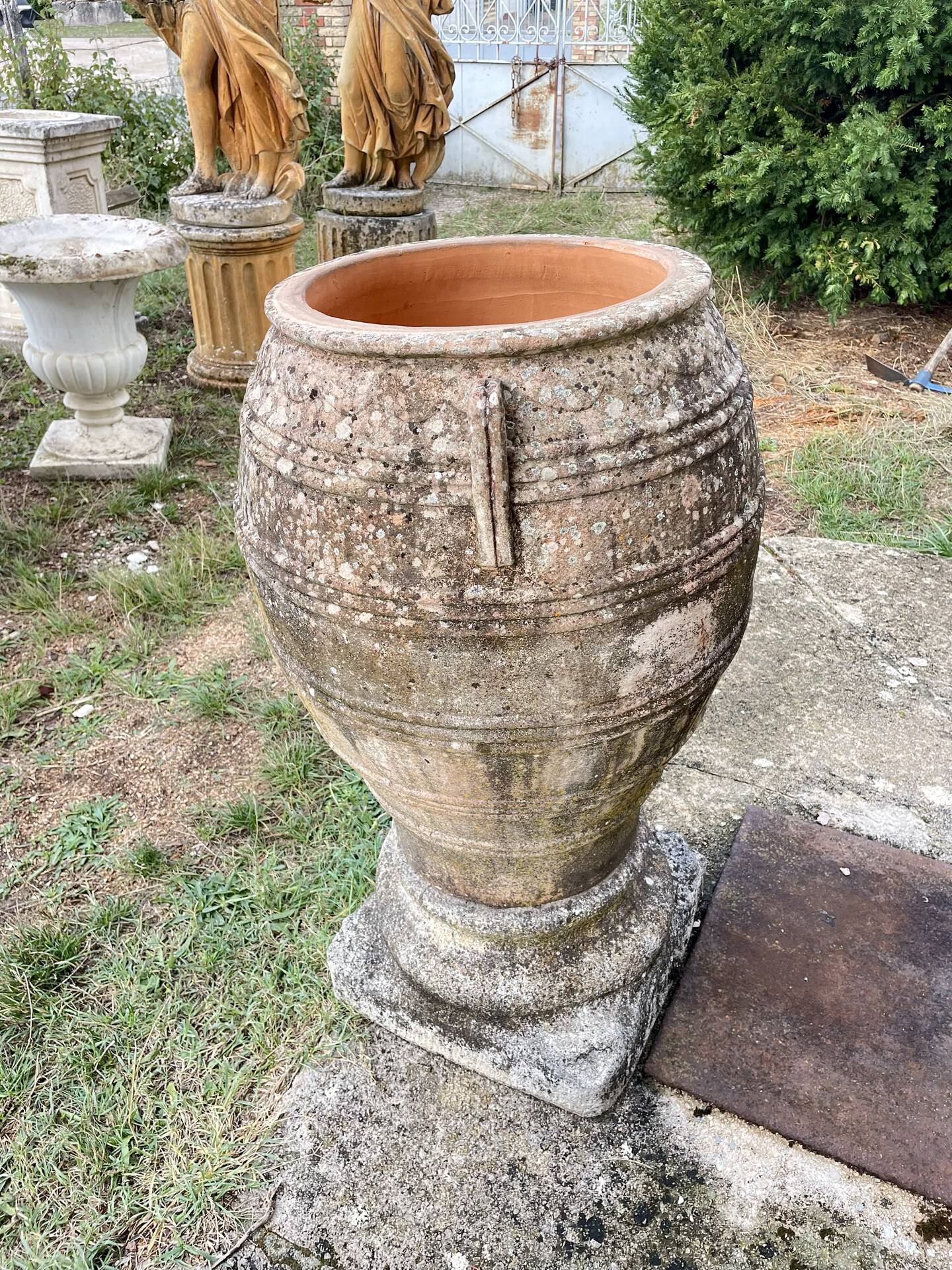 Large Cretan jar in terracotta with three handles on a stone base.