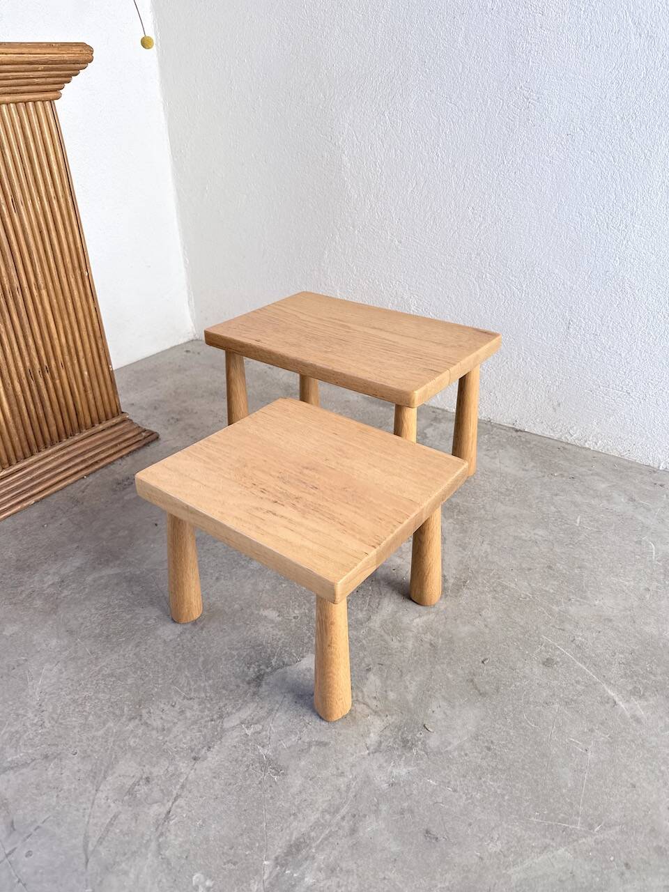 Two stools or small nesting tables in light oak.
