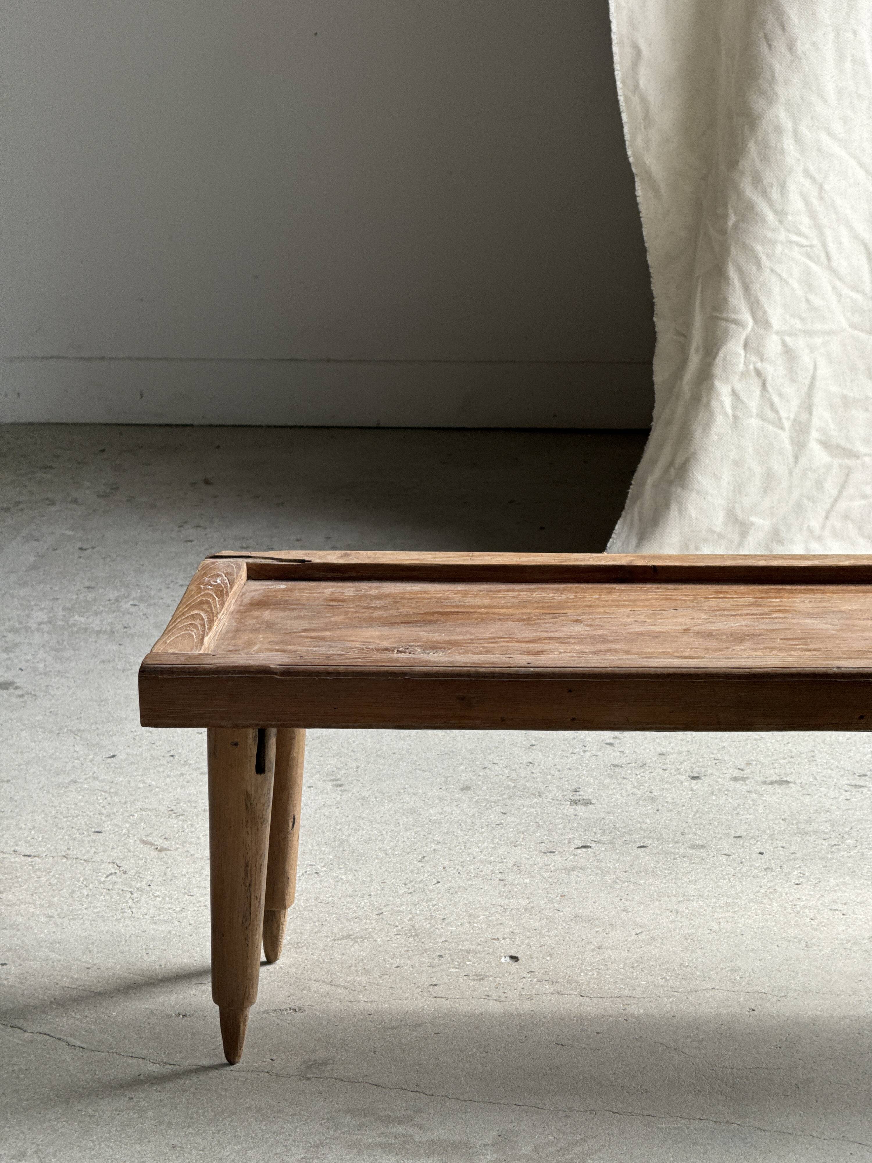 Brown Indonesian teak coffee table, with a border and cylindrical legs H40 L103.