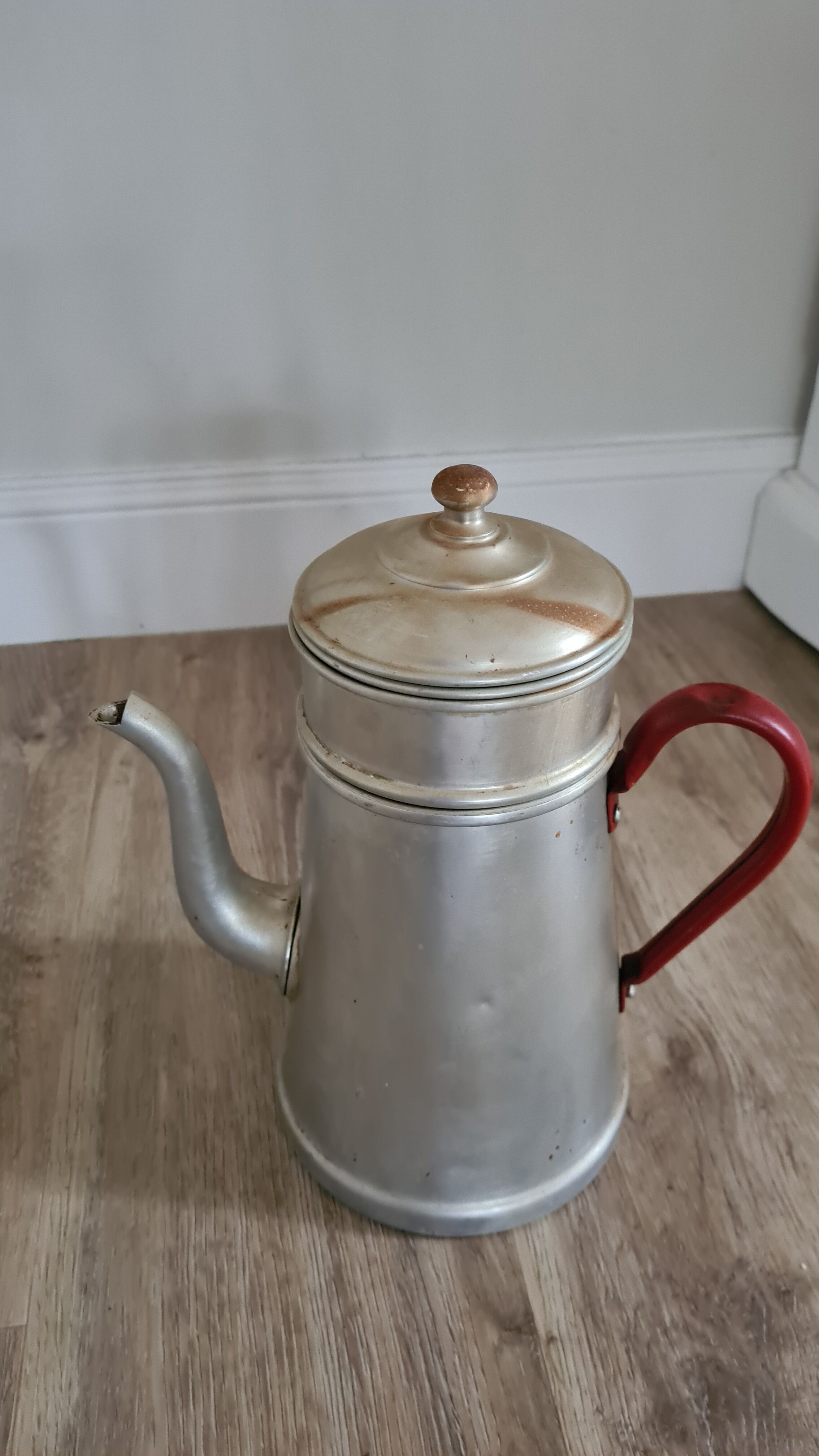 Old enamelled coffee maker in red handle aluminum