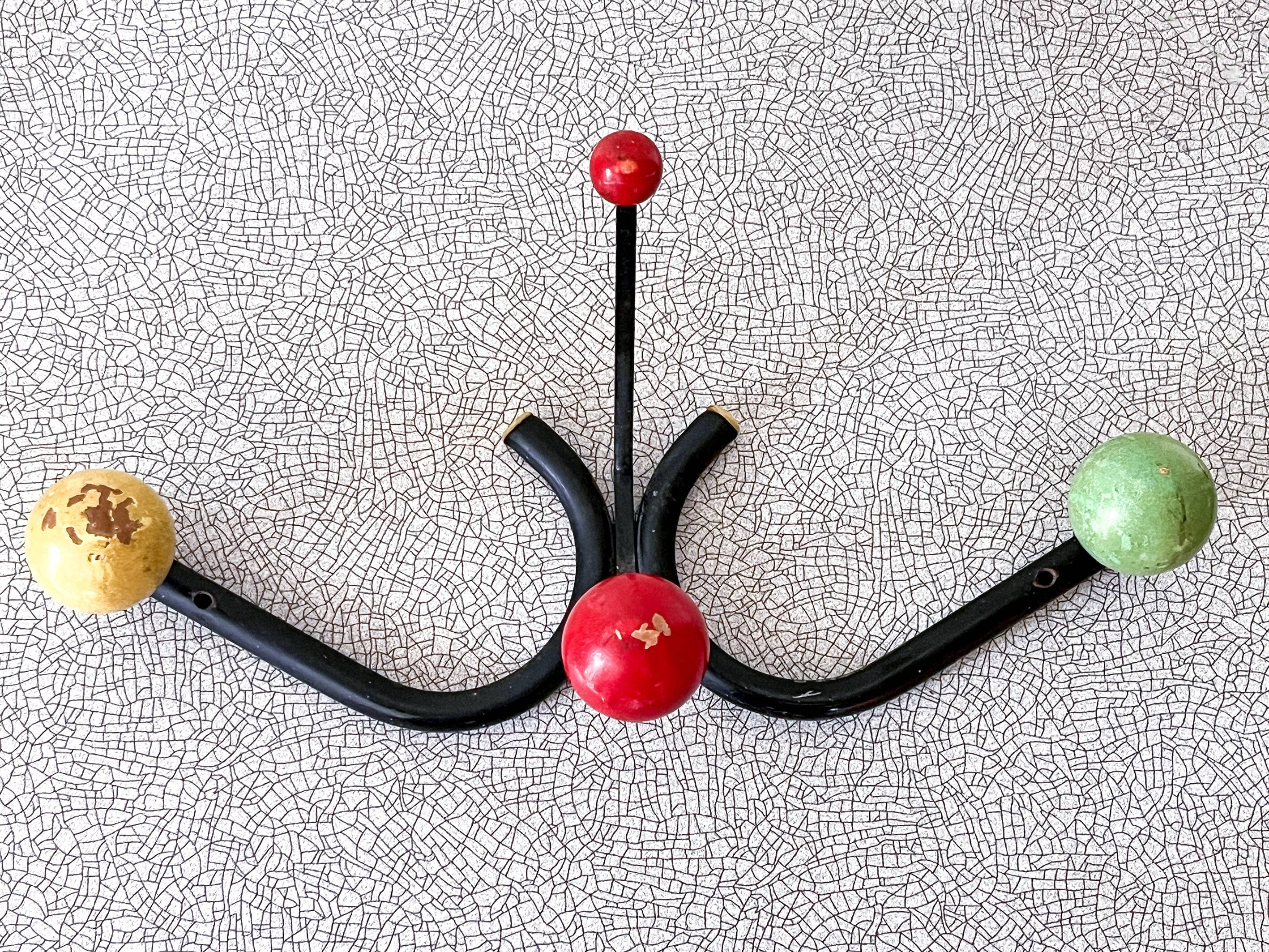 Vintage metal and wood coat rack in yellow/red/green.