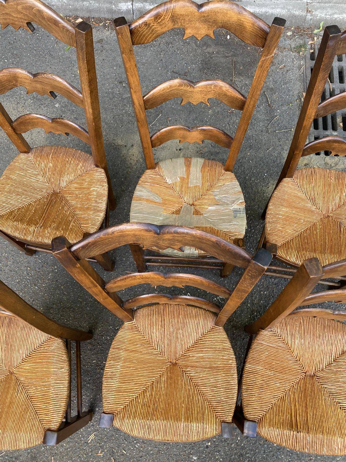 6 solid wood chairs with straw seats and butterfly carved backs.