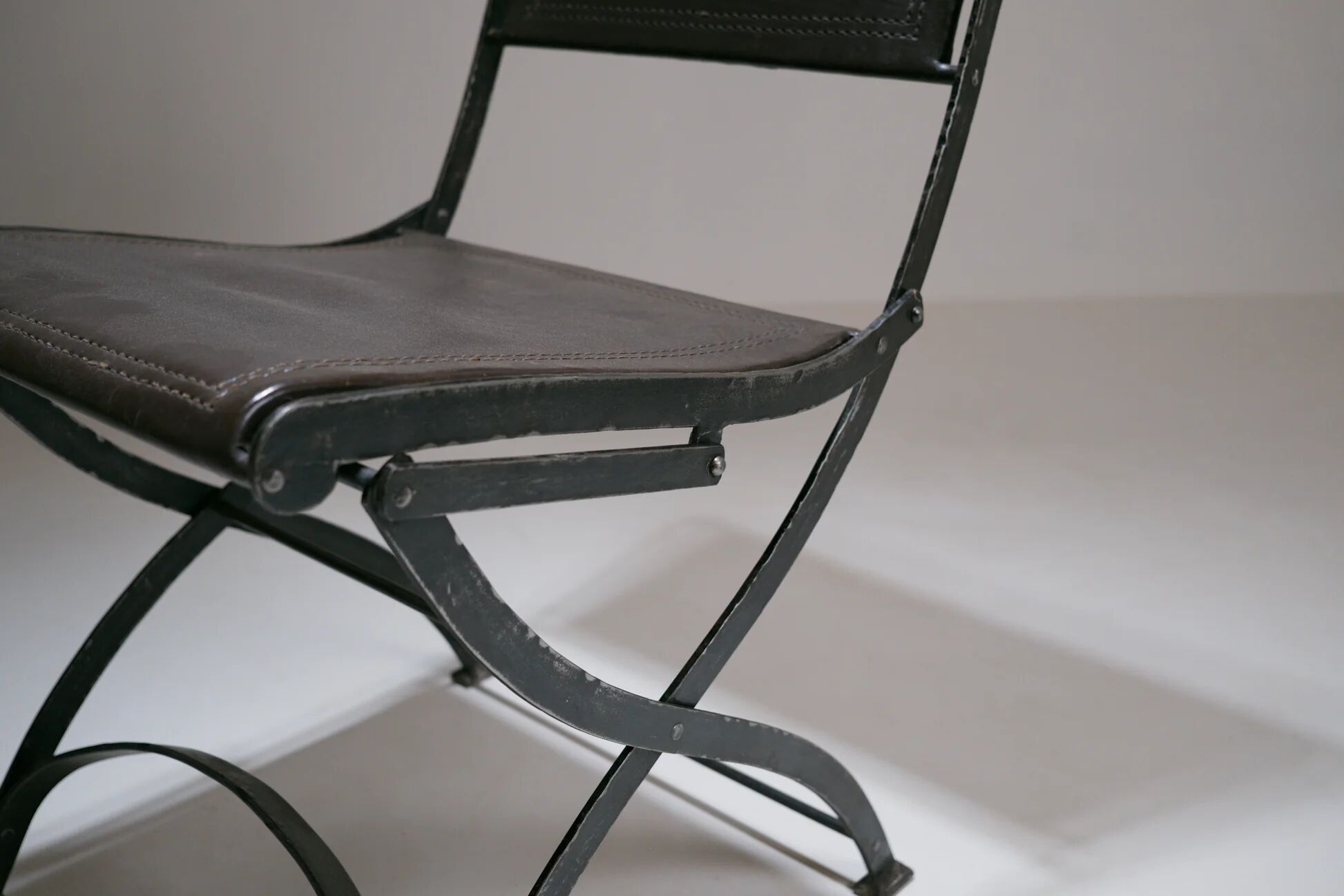 Foldable chair in wrought iron and leather. c. 1950