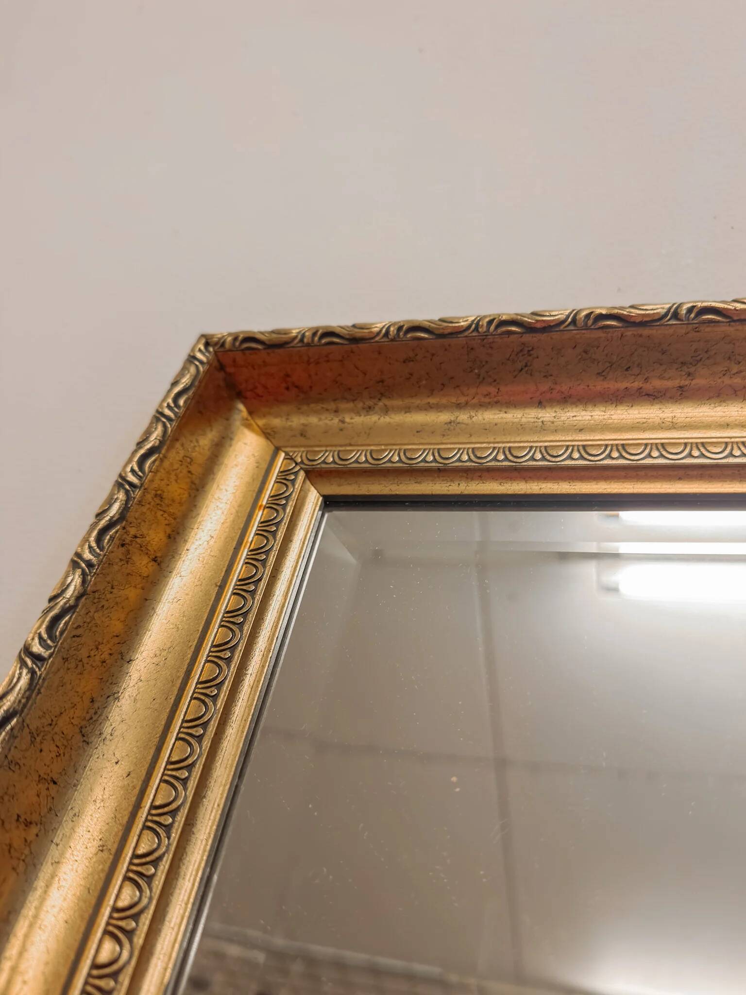 XL vintage bevelled mirror with a gold frame.