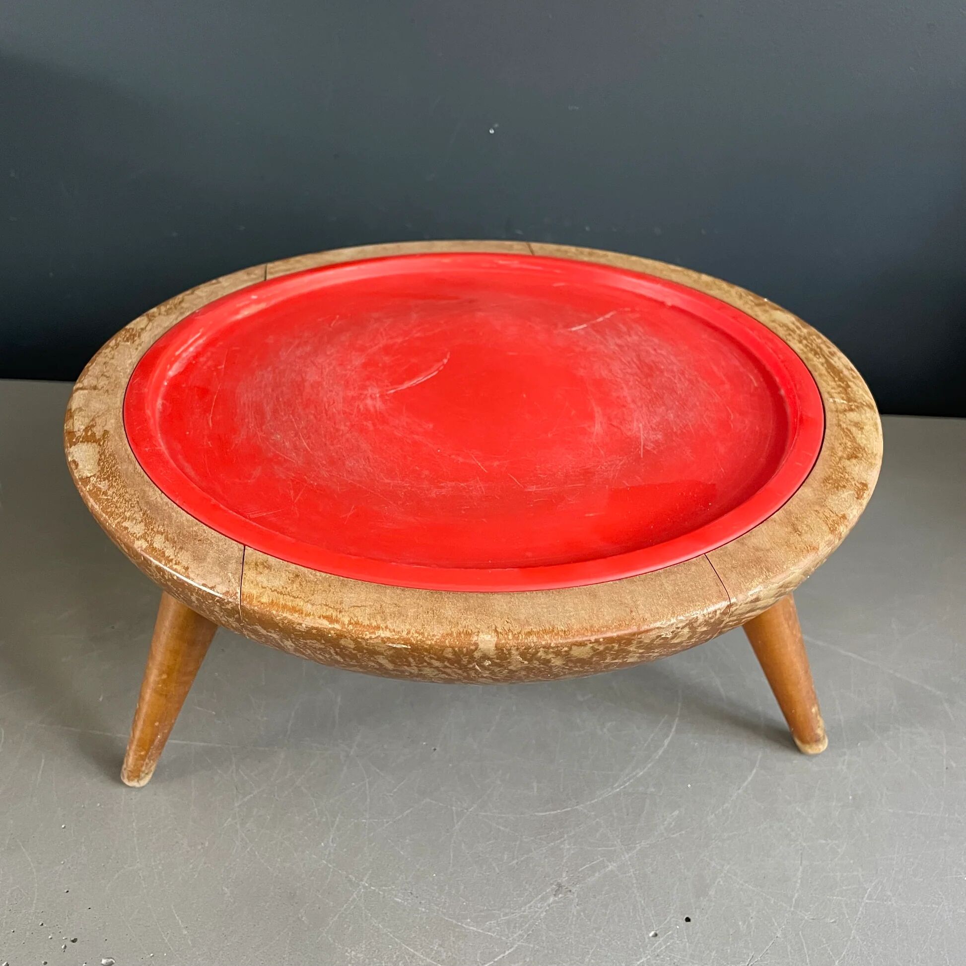 Wooden and red plastic compasses plant stand.