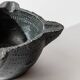 Vintage ceramic ashtray from the 1960s, black, hand-sculpted texture, organic shape.
