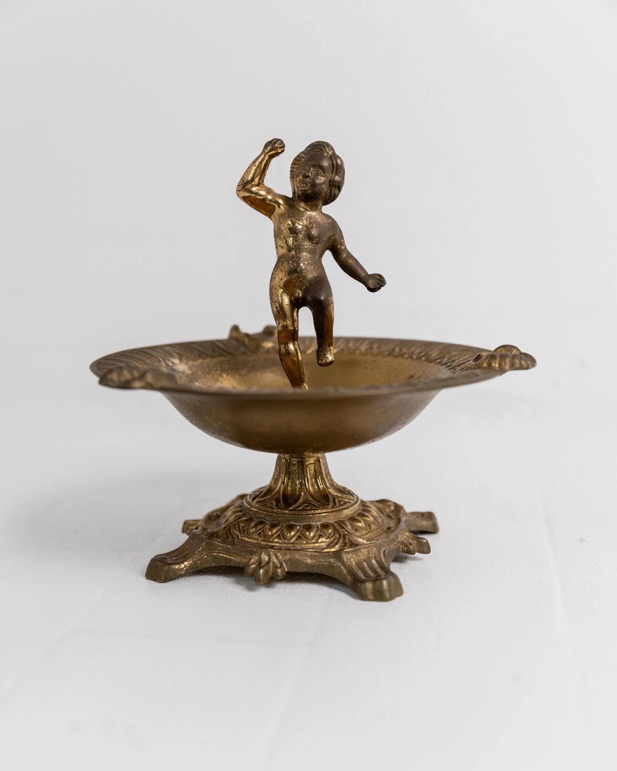 Vintage brass ashtray from the 1940s with a nude boy figurine on a footed base.