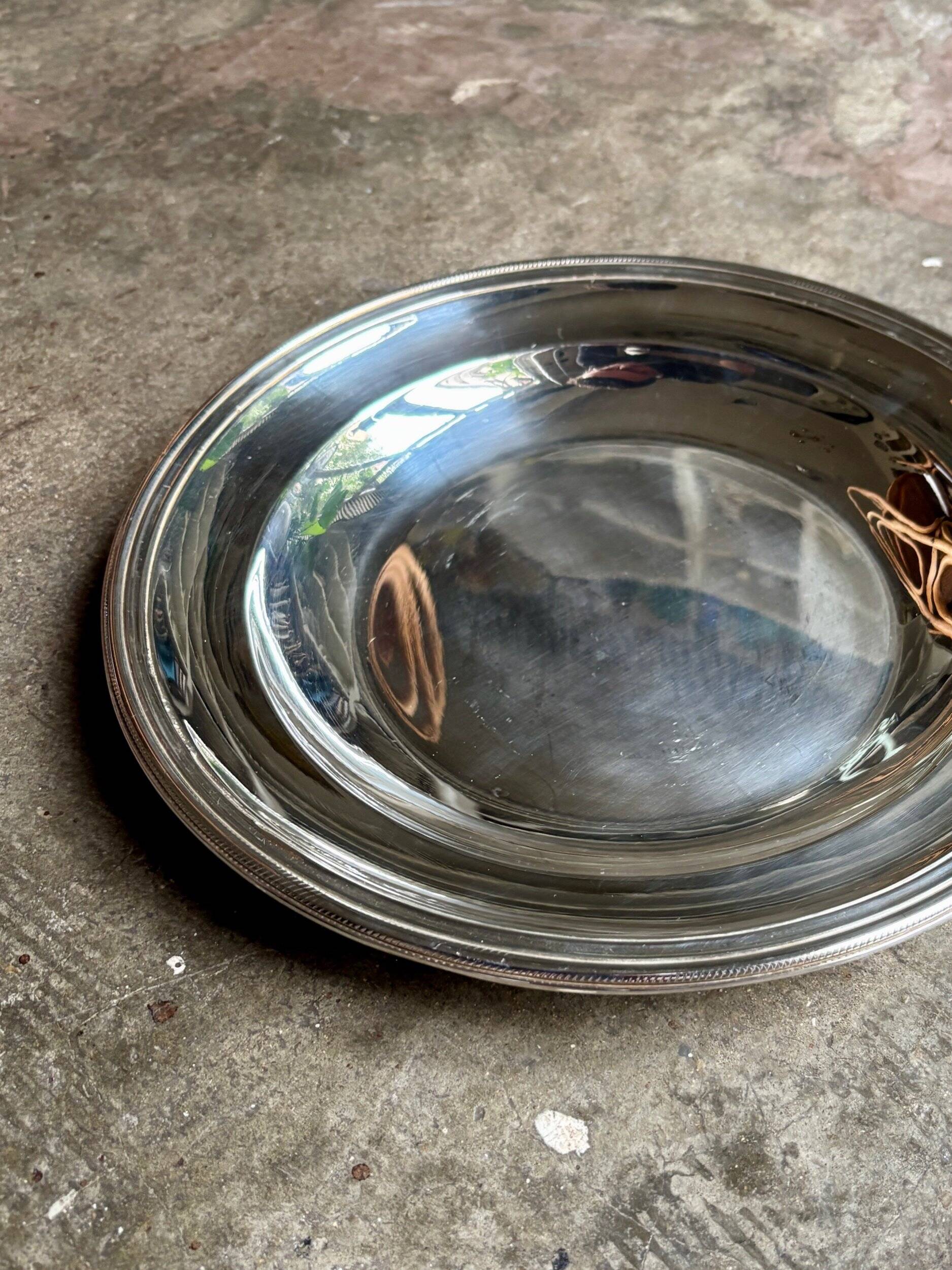 Round, hollow silver-plated metal dish