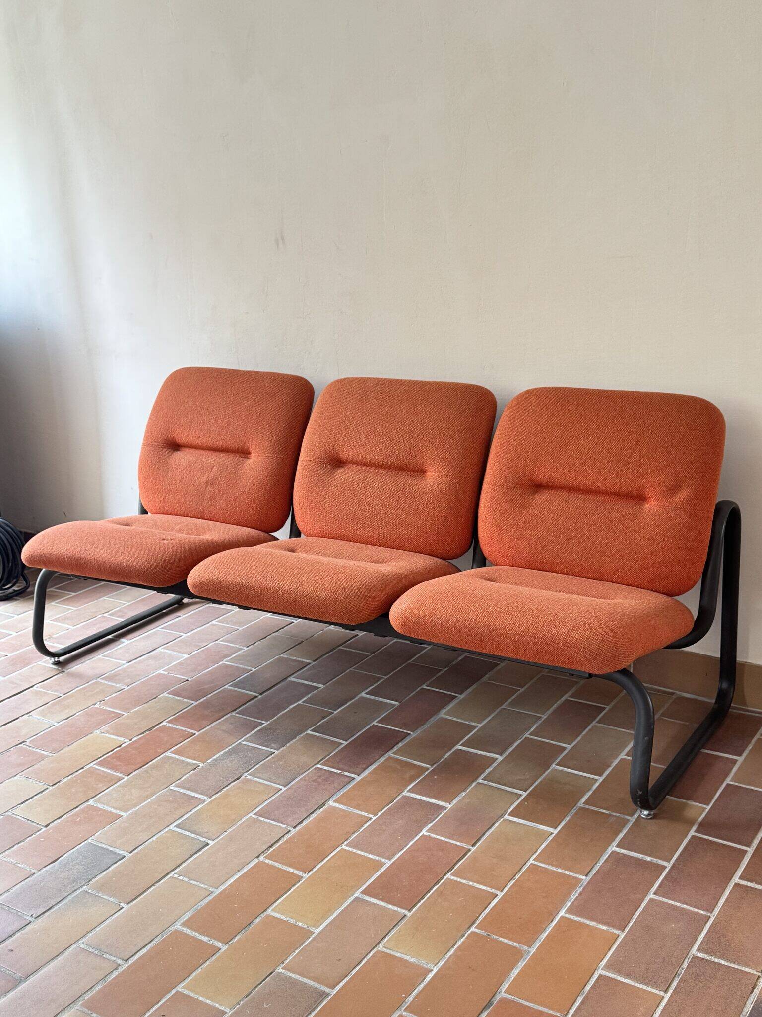 Strafor 3-seater bench, orange upholstery and sled base, 1970s.