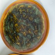 Set of 4 flamed enamel plates in green and amber from the 60s-70s.