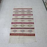 Tribal bohemian kilim rug with geometric pattern in wool.
