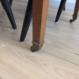 Antique wooden folding table with a patina and brass wheels.
