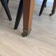 Antique wooden folding table with a patina and brass wheels.
