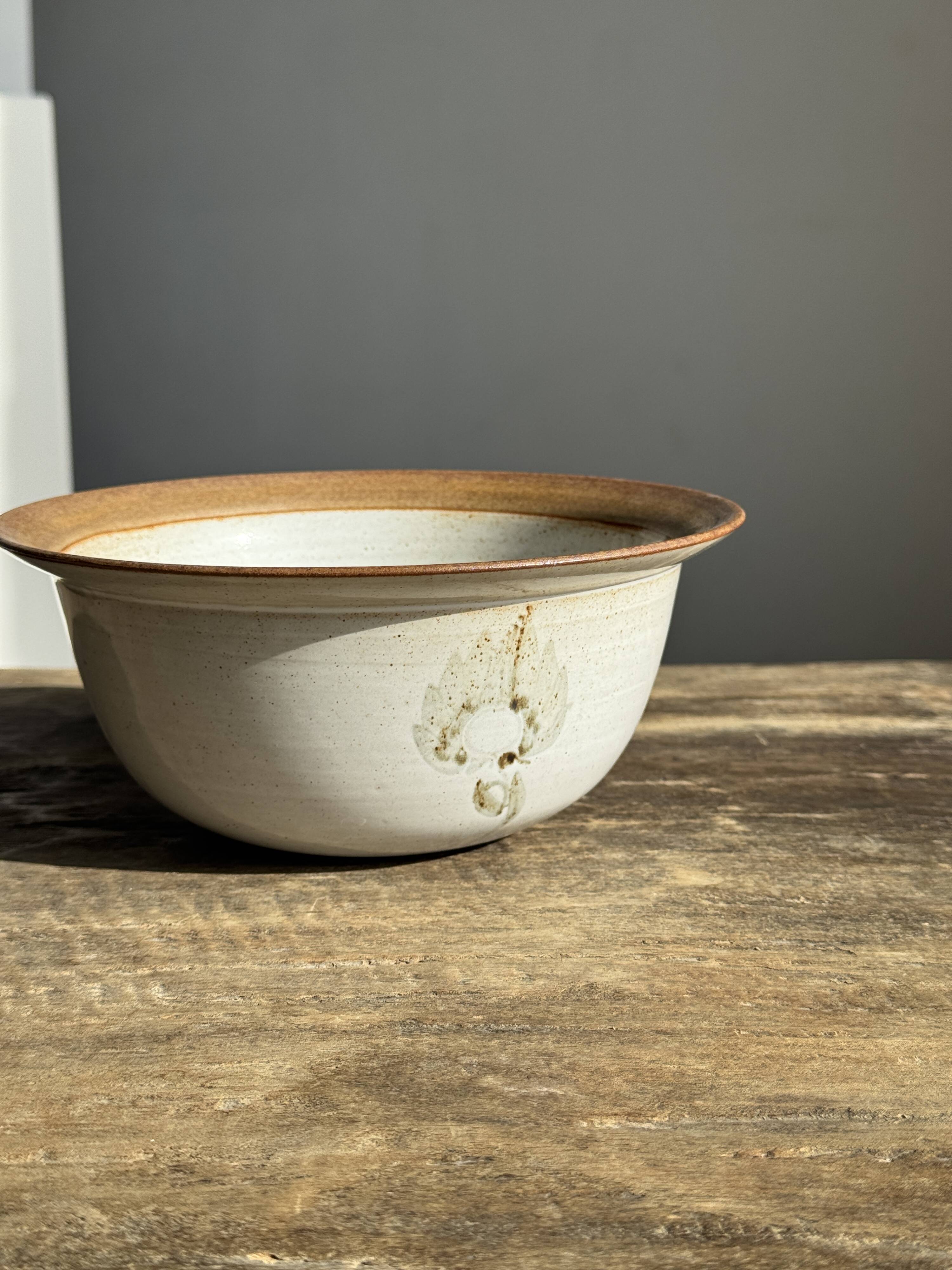 Small thick stoneware bowl with a stylised flower pattern in white on the outside, b