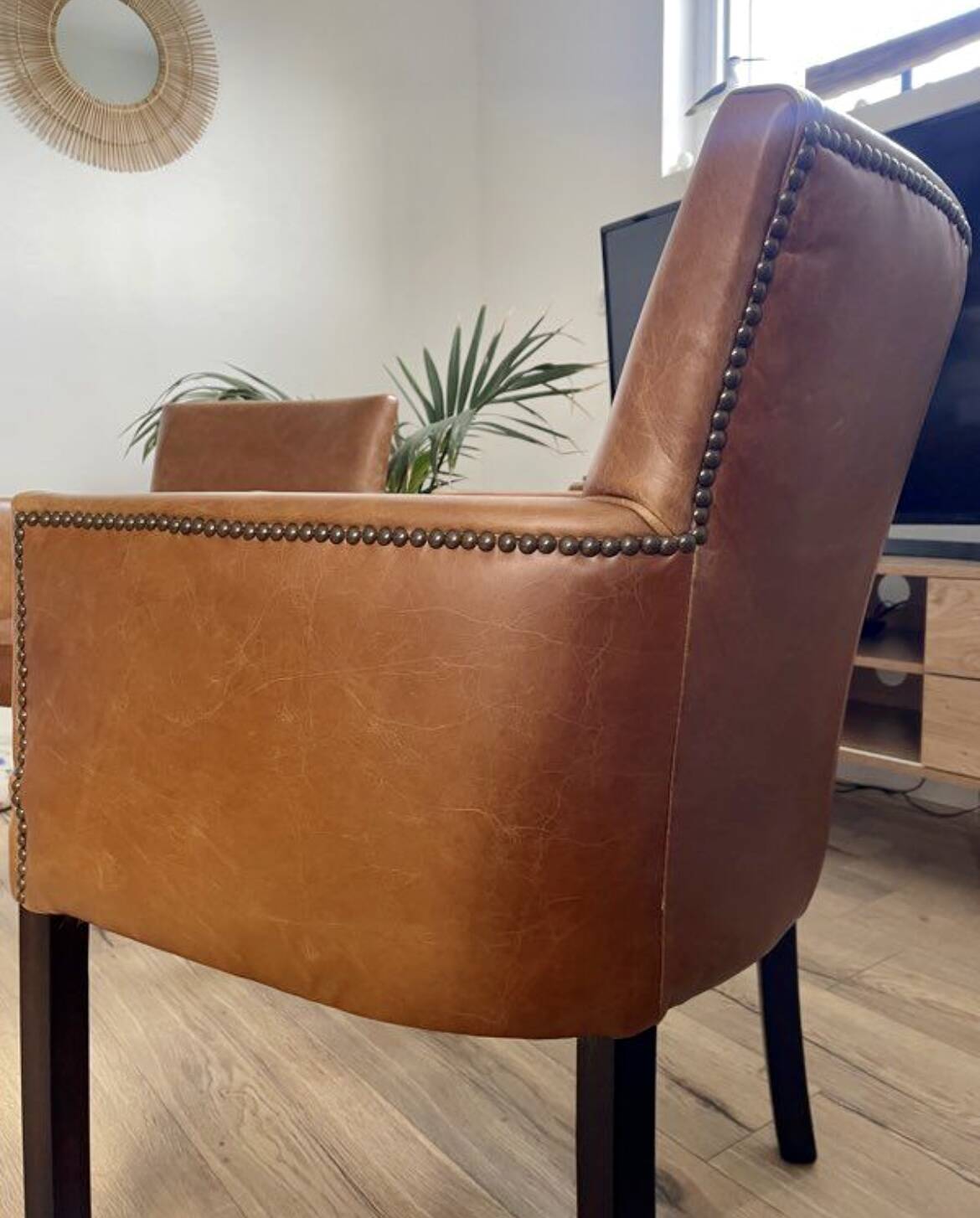 Chair with armrests in aged brown cowhide leather