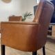 Chair with armrests in aged brown cowhide leather