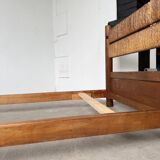 Brutalist style bed with chain and straw
