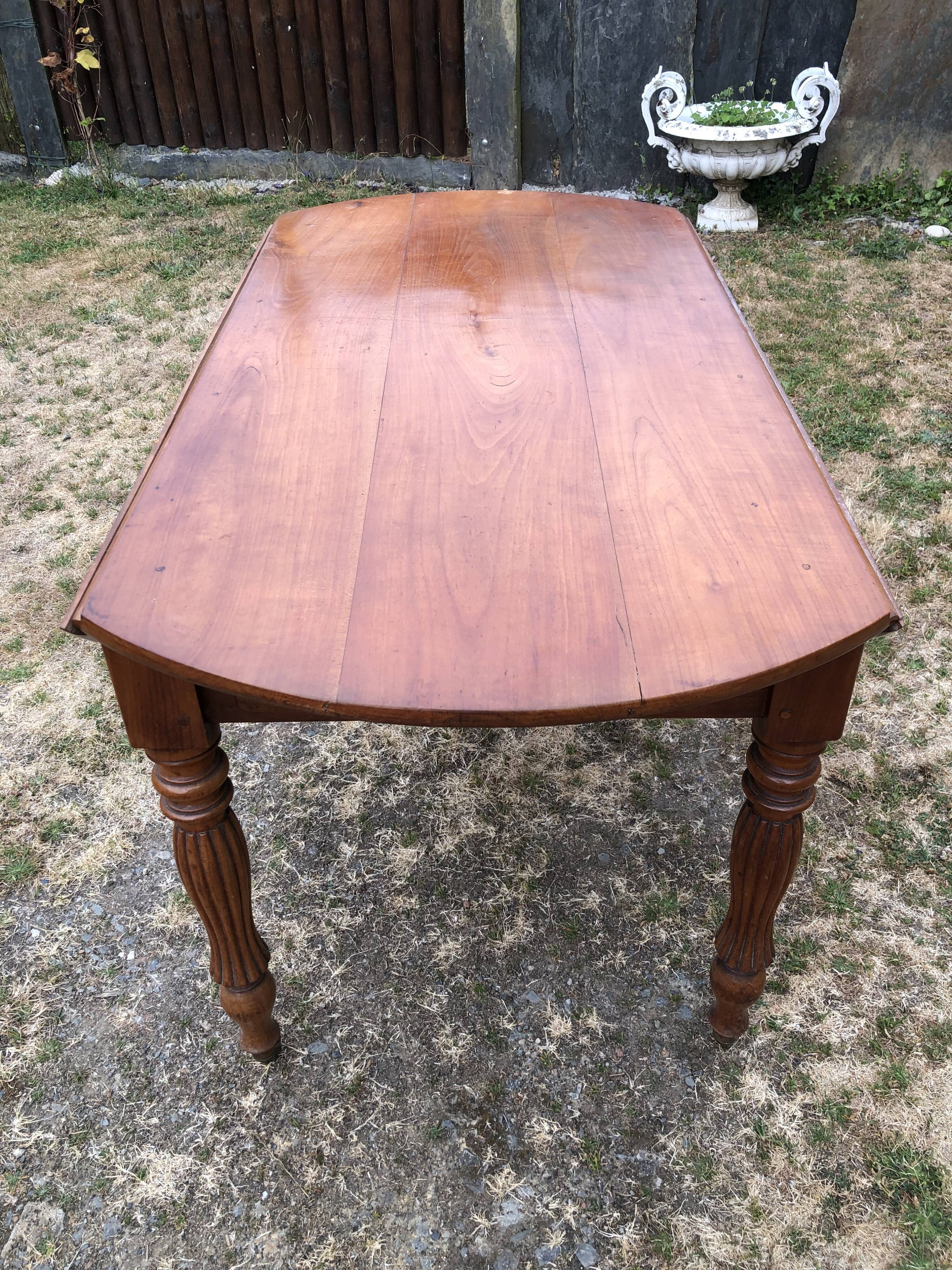 Louis Philippe oval drop-leaf table in solid cherry wood with 2 drawers.
