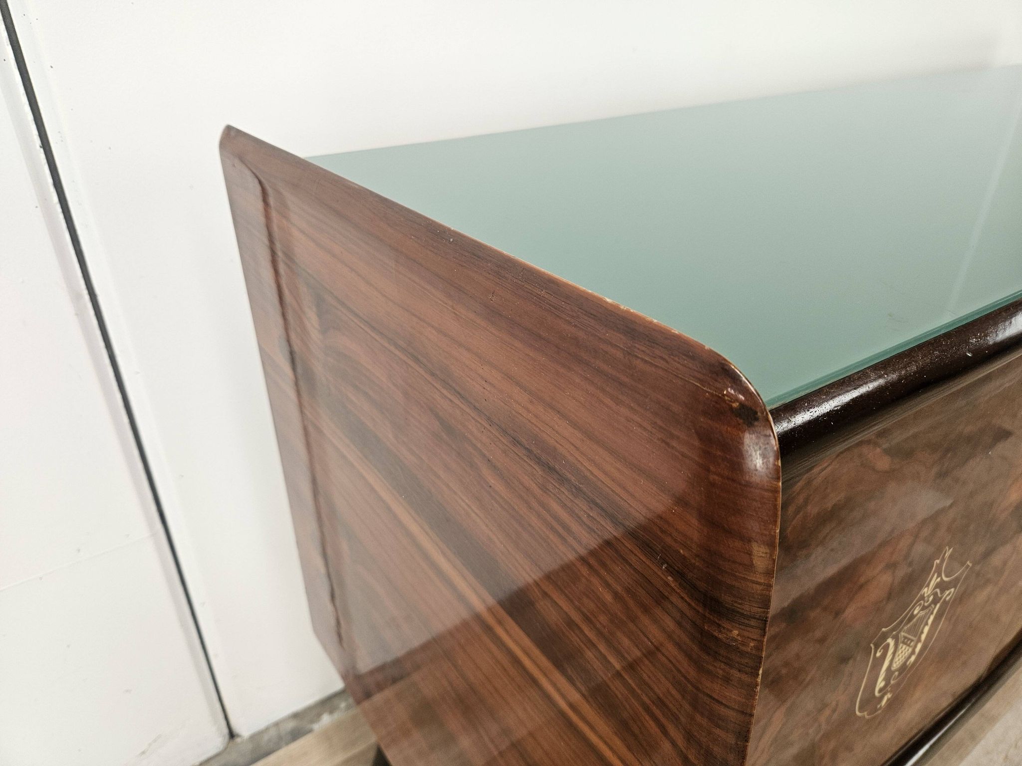 1950s mahogany sideboard with a glass top and central bar.