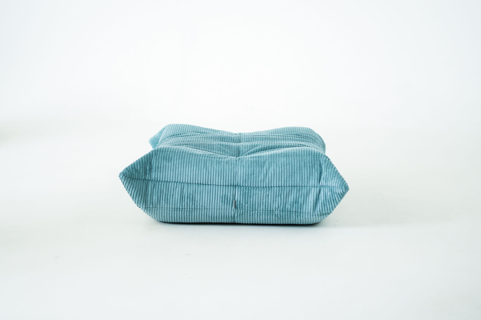 Ensemble de fauteuil et pouf Togo en velours côtelé bleu clair.