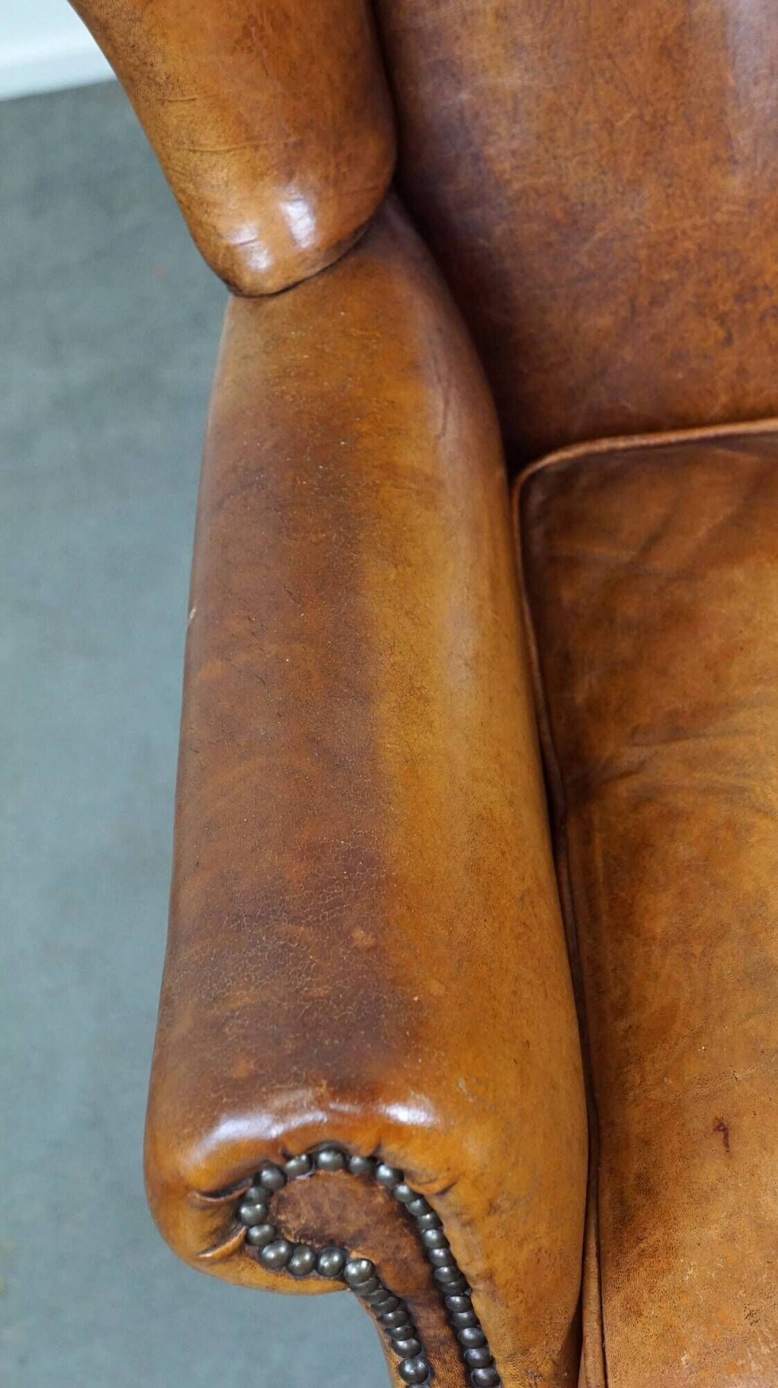 Positively lived-in sheepskin leather wing chair with pleasant seating comfort