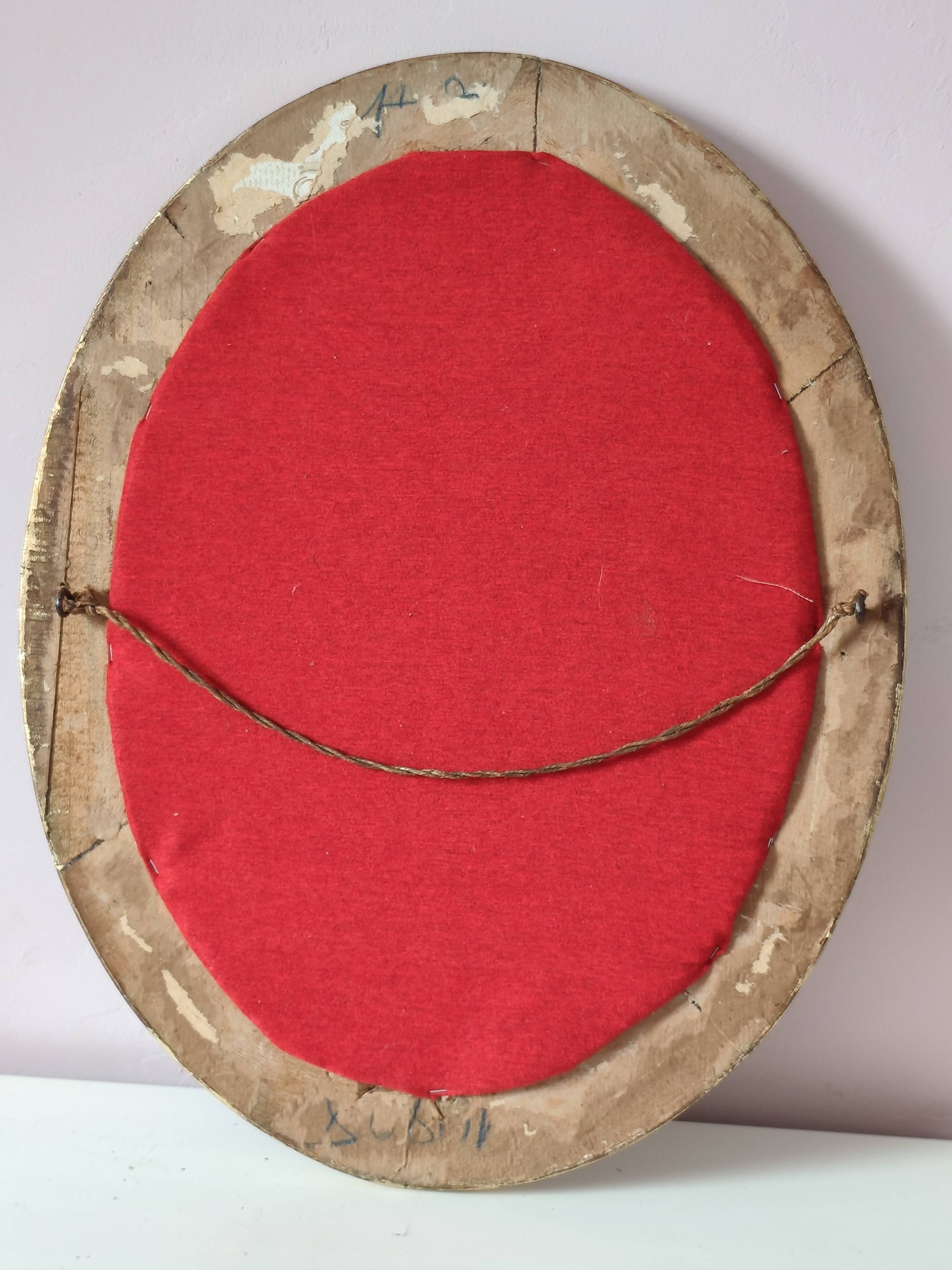 Antique medallion mirror with a gilded and relief-carved frame.
