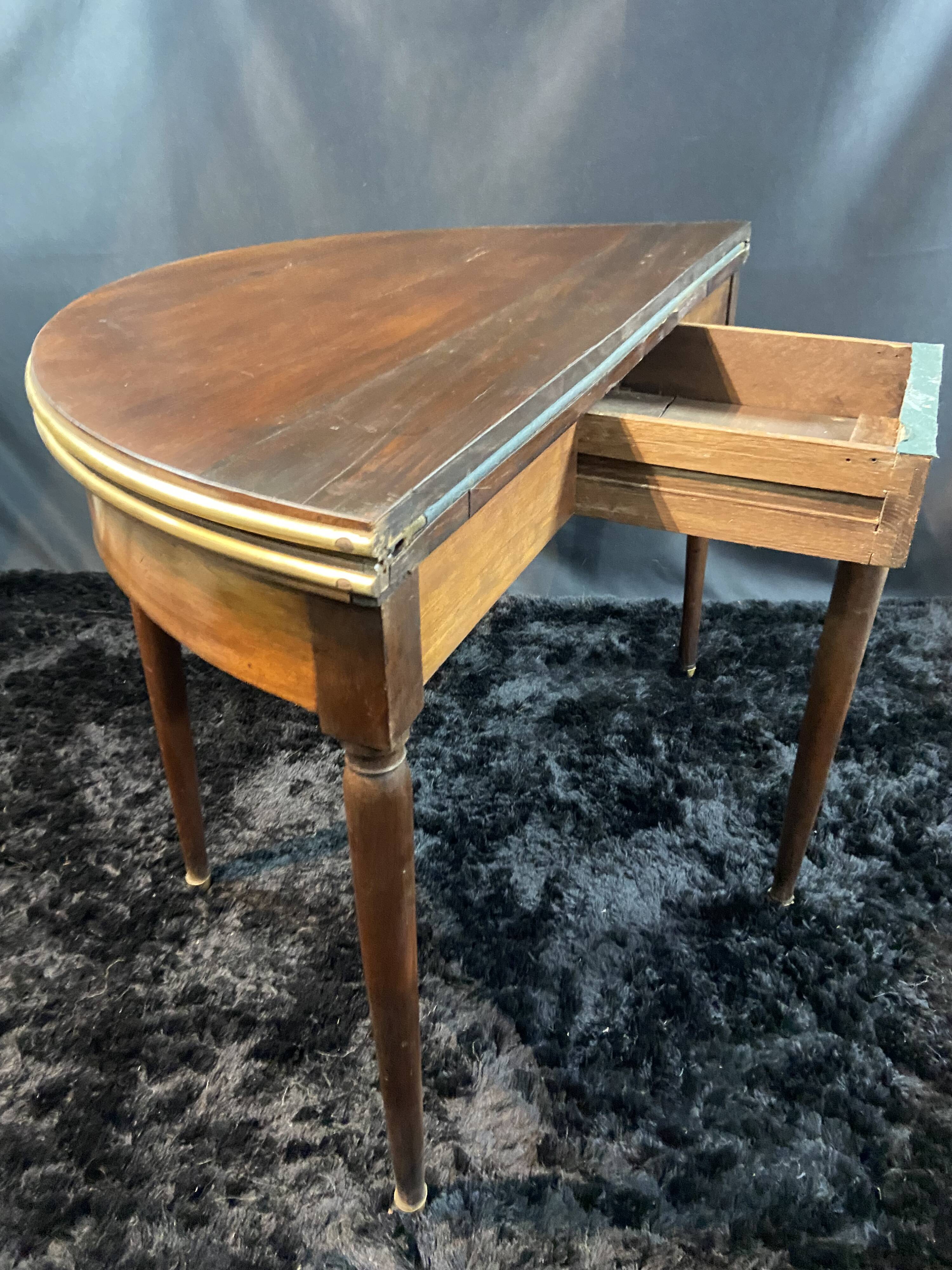 A Louis XVI period mahogany half-moon table forming a console/games table