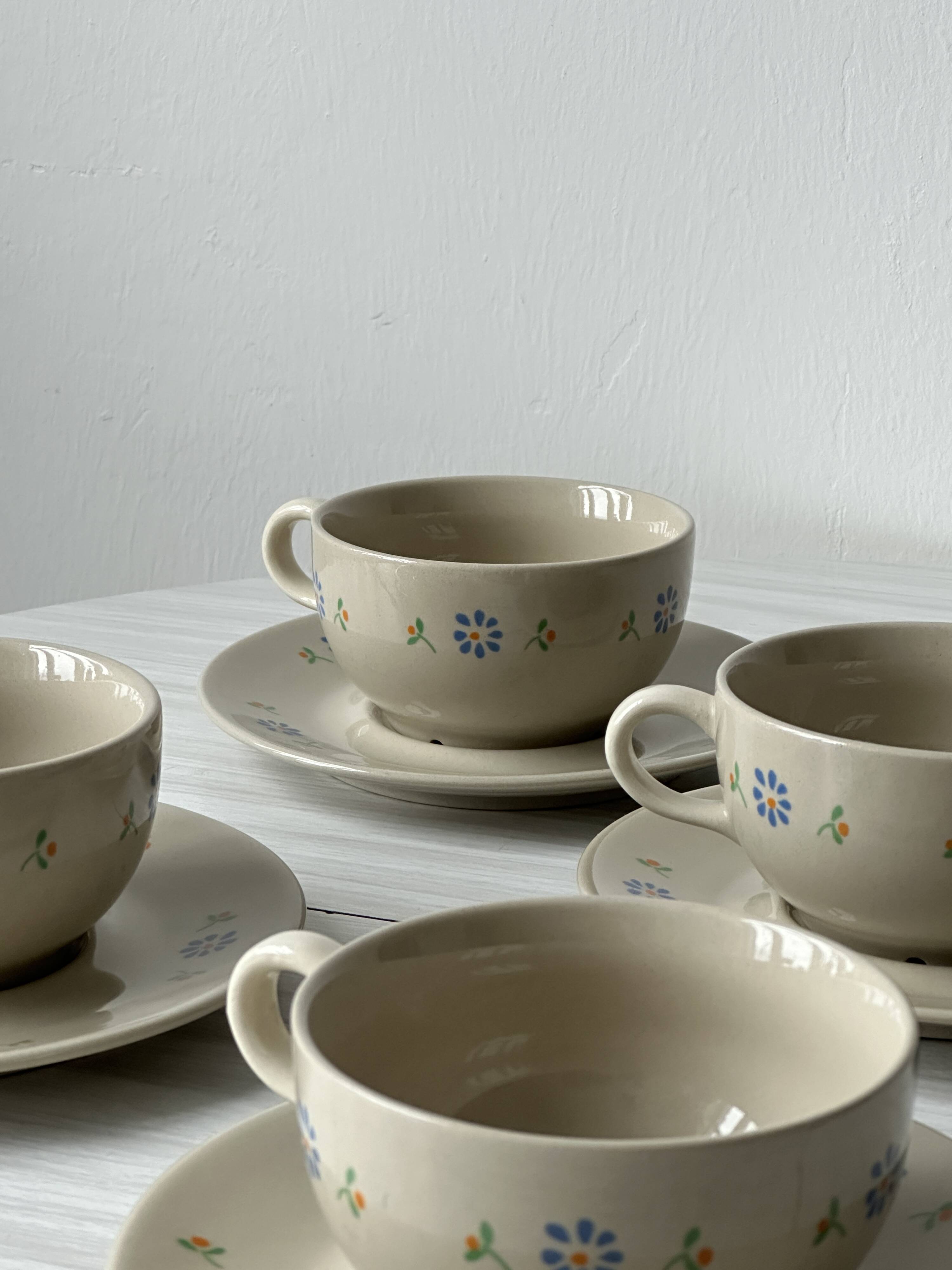Ceramic cups and saucers with flower decoration